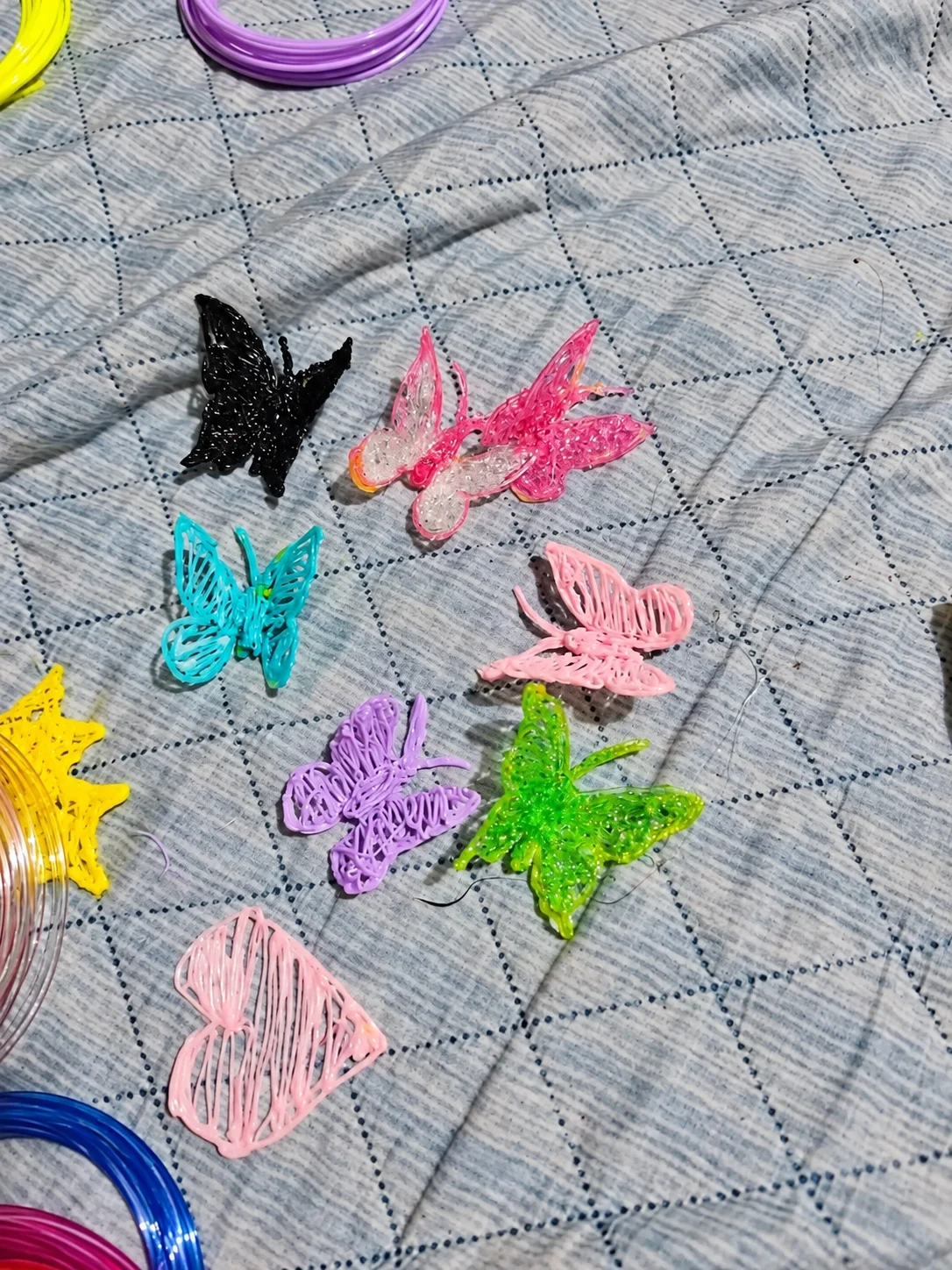 Imagem adaptada de borboletas e um coração coloridos feitos com filamento