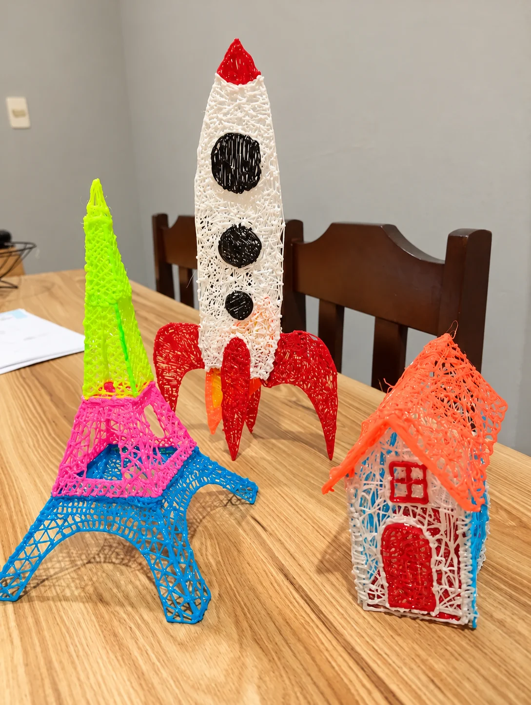 Imagem adaptada de um foguete, uma torre e uma casinha feitos com filamento colorido